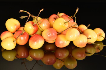 Yellow sweet cherry, close-up, on a black background.