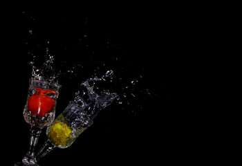Tomato and lemon splashing into clear water on Black background, splash healthy food diet freshness concept.