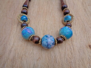 Wooden necklace with brown background. The necklace on the wooden background.