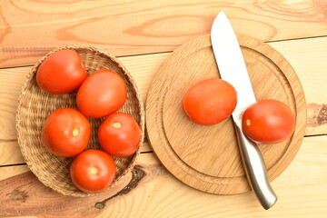Red plum-like tomato, close-up, on a wooden table.