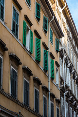 Closed shutters on the facade of an old building in Italy