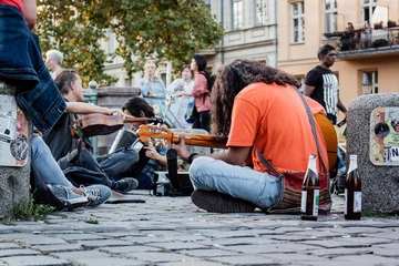 Fototapeten Homeless musician playing guitar, busking in the street © Full Frame Visuals