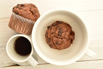 Chocolate muffins on a white wooden table, close-up.