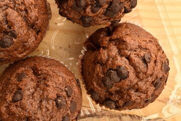 Chocolate muffins on a wooden table, close-up.