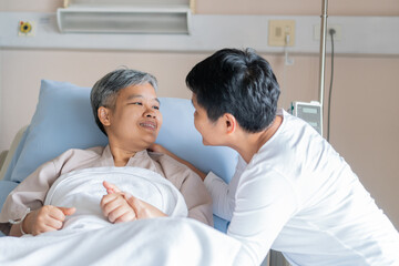 Fototapeta premium Happy Woman Visits Best friends holding hands for recovering that sick lying in Hospital, looking with cheerful love hopeful emotional, Encouragement comforting Recovering from family healthy moment.