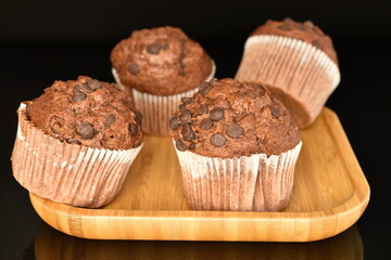Chocolate muffins, close-up, on a black background.