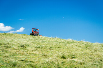 Trattore, cielo e prato