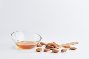almonds with a wooden spoon and honey in a piala on a white background. healthy food. copy space...