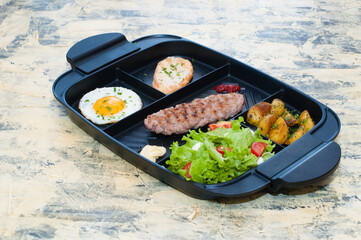 Breakfast, fried steak or cutlet, salad with tomato and green vegetables, croutons, potatoes, egg side view, light background. The concept of healthy diet, diet, menu, good nutrition.