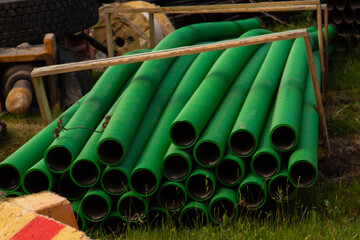 Pile of green plastic pipes at a construction site