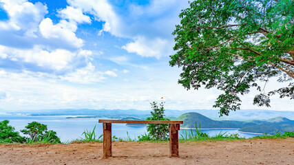 Fototapeta na wymiar Lookout point with resting wooden bench. Beautiful scenery of nature with a large reservoir above the Srinagarind Dam at Rai Ya Yam view point in Si Sawat District, Kanchanaburi Thailand.