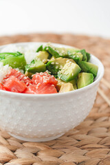 Hawaiian poke bowl with smoked salmon lox, avocado, white rice, cucumber and sesame seeds. Bright and airy feel 
