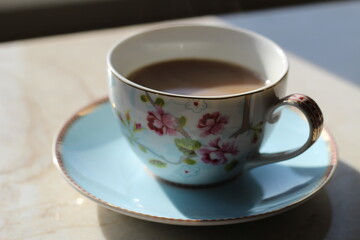 English blue and white tea cup on saucer in fine china with delicate flowers and gold edging