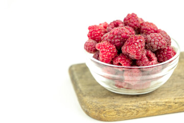 fresh ripe raspberry in a glass transparent bowl on white background