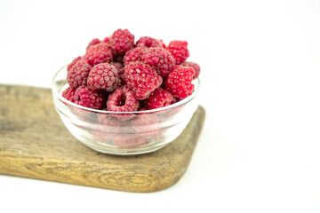 fresh ripe raspberry in a glass transparent bowl on white background