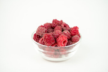 fresh ripe raspberry in a glass transparent bowl on white background