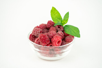 fresh ripe raspberry in a glass transparent bowl on white background