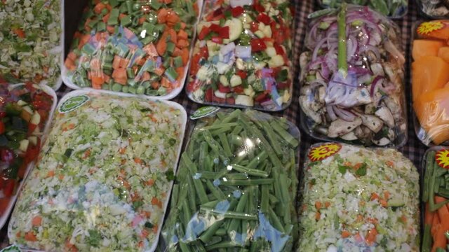 Mixed cut vegetables packed in plastic containers for sale in grocery shop