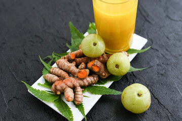 Raw turmeric roots juice, amla, neem leaf Indian Ayurveda natural herbal medicine, Kerala South India. Traditional Indian cuisine use powdered turmeric spices in curry, antiseptic Ayurvedic treatment