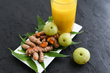Raw turmeric roots juice, amla, neem leaf Indian Ayurveda natural herbal medicine, Kerala South India. Traditional Indian cuisine use powdered turmeric spices in curry, antiseptic Ayurvedic treatment