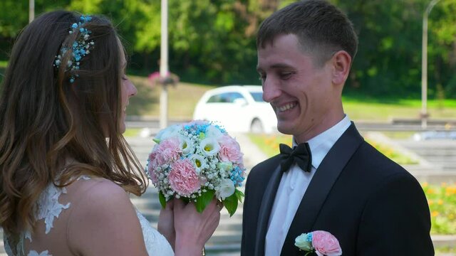 Bride and Groom Walk in Park Looking at Each Other. Urban Scene. Slow motion