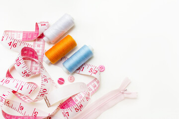 Sewing kit. Composition with threads and sewing accessories on a white background, an even layer. Colored satin ribbons