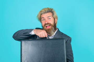 Business. Office worker. Smiling businessman with suitcase. CEO. Bearded businessman in suit. Business concept. Office concept. Bearded businessman with case.