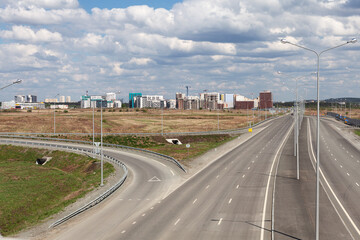 Motorway interchange, highway, top view. On the horizon-the construction of a residential district.