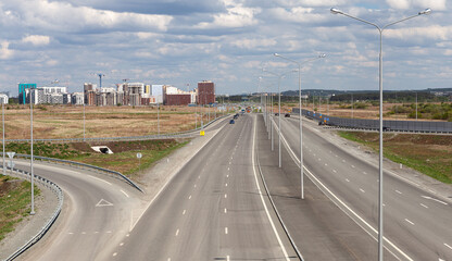 Motorway interchange, highway, top view. On the horizon-the construction of a residential district.