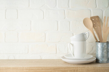 Kitchen background with dishware, utensils, cup and plate on wooden shelf