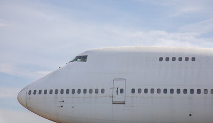 Close-up and high-view shot of airplane's head part is under beautiful blue sky background  which has been used for flight service for long time showing water stain and rust on the metal surface.