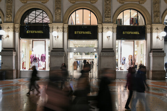 Milan, Italy - January 11, 2020: People passing by a Stefanel showcase at night