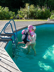 The girl and her daughter, a family of Caucasians, relax and swim in the pool.