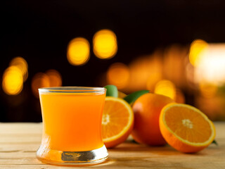 Fresh orange juice in a clear glass on a wooden background, fruits that contain vitamins.