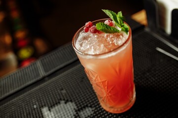 Cranberry summer lemonade decorated with mint on a bar counter