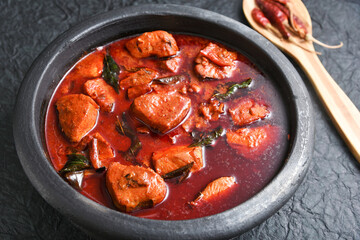 Kerala red fish curry is a hot and spicy seafood cuisine masala gravy Alappuzha India. cooked with ingredients curry leaves, kokkum, coconut milk. Brown rice and fish is popular dish in coastal area.