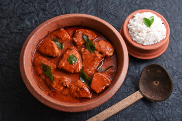 Kerala red fish curry is a hot and spicy seafood cuisine masala gravy Alappuzha India. cooked with ingredients curry leaves, kokkum, coconut milk. Brown rice and fish is popular dish in coastal area.