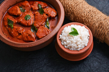 Kerala red fish curry is a hot and spicy seafood cuisine masala gravy Alappuzha India. cooked with ingredients curry leaves, kokkum, coconut milk. Brown rice and fish is popular dish in coastal area.
