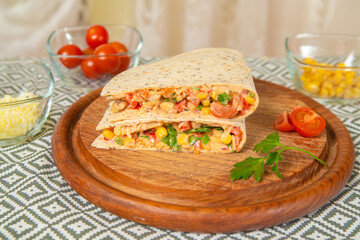 Mexican quesadilla with chicken, cheese, and peppers on wooden table.
