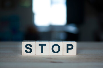 The word stop on a wooden cube. Letter constructor