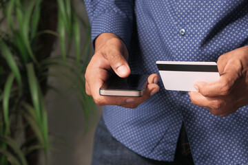 Man hand holding credit card and using smart phone shopping online 