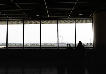 Silhouette of tourists are waiting for boarding time at lounge of donmuang  internation airport bangkok, Thailand.