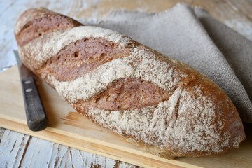 Grain loaf and bread knife on a tabletop