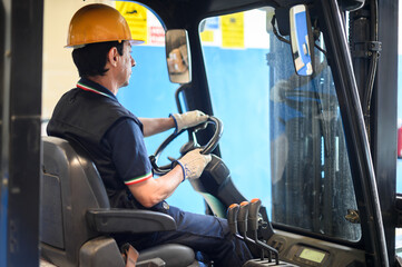 A construction worker driving a forklift in an industrial plant © Minerva Studio