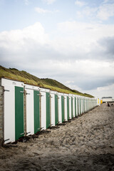 Fototapeta na wymiar Row of small beach cabins on a Netherland beach at the North Sea