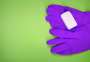 Wash your hands. Protective gloves with soap bar on green background flat lay. Infection prevention.