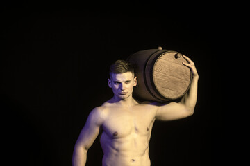 Sexy man with a muscular body working in half naked with a barrel of beer.