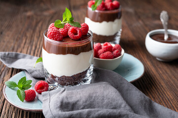 Delicious layered dessert with cream cheese, crushed chocolate cookies, topped with ganache and...