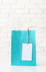 blue shopping bag with a blank white tag on white table