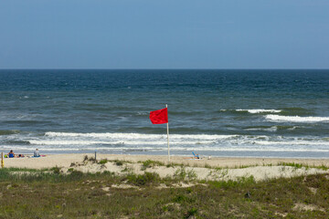 Red flag beach warning on the North Carolina coast with people on beach